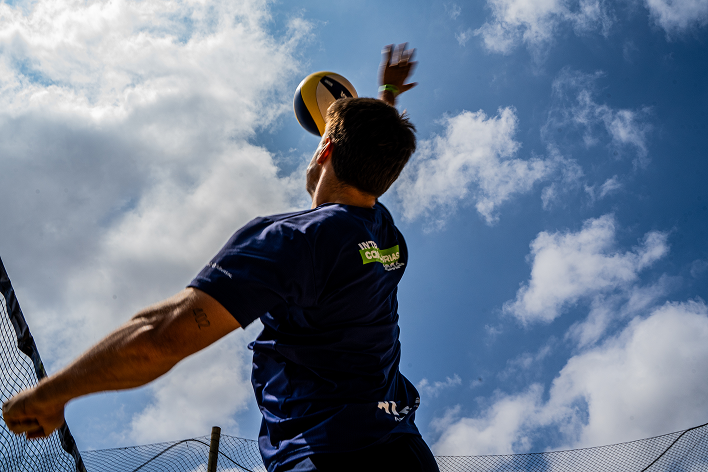 Jogador de vôlei de praia saltando para atacar